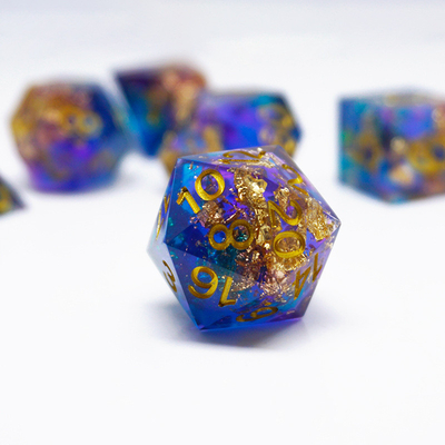 Un jeu de dés en résine en feuille d'or bleu personnalisé en différentes couleurs