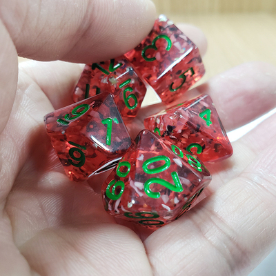 Des pommes de grenade rouges, des séquins de résine, des dés de bord, des jeux de dés.