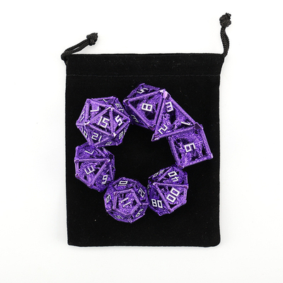 Un jeu de dés creux en métal, un dragon polygonal, un donjon de fumier et 7 dés.