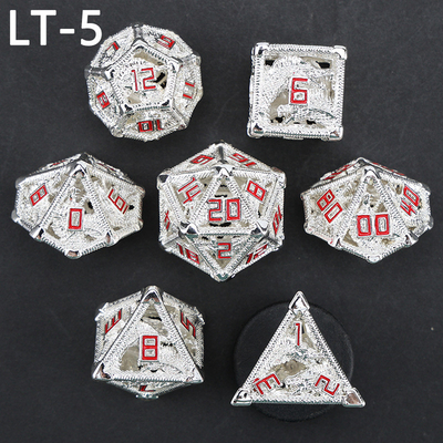 Un jeu de dés creux en métal, un dragon polygonal, un donjon de fumier et 7 dés.
